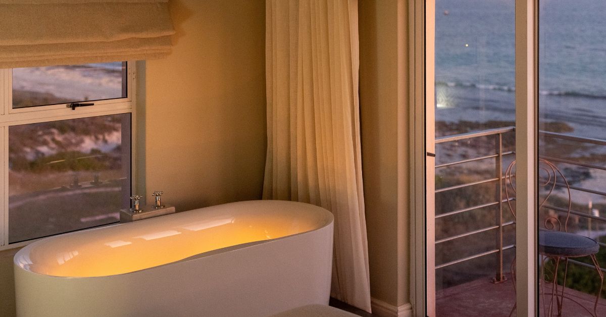 A bathtub with candles in it and a view of the ocean at Blue Bay Lodge