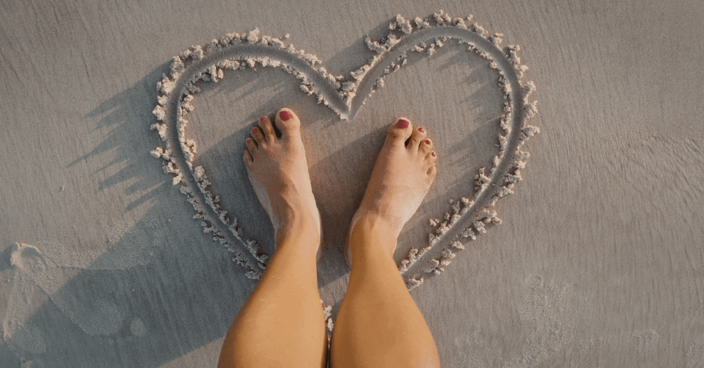 Woman with feet in the sand on the West Coast