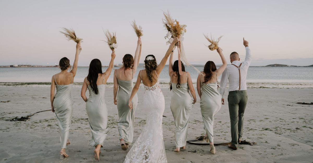 Small Wedding Venue Feature Image- Bridesmaids walking towards the ocean holding flowers