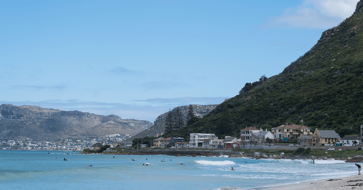 View of many surfers surfing in clear blue water in False bay , Muzienberg