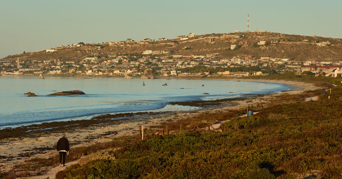 coastal towns western cape - View of a person walking on Saldanha Bay beach with the town in the distance 