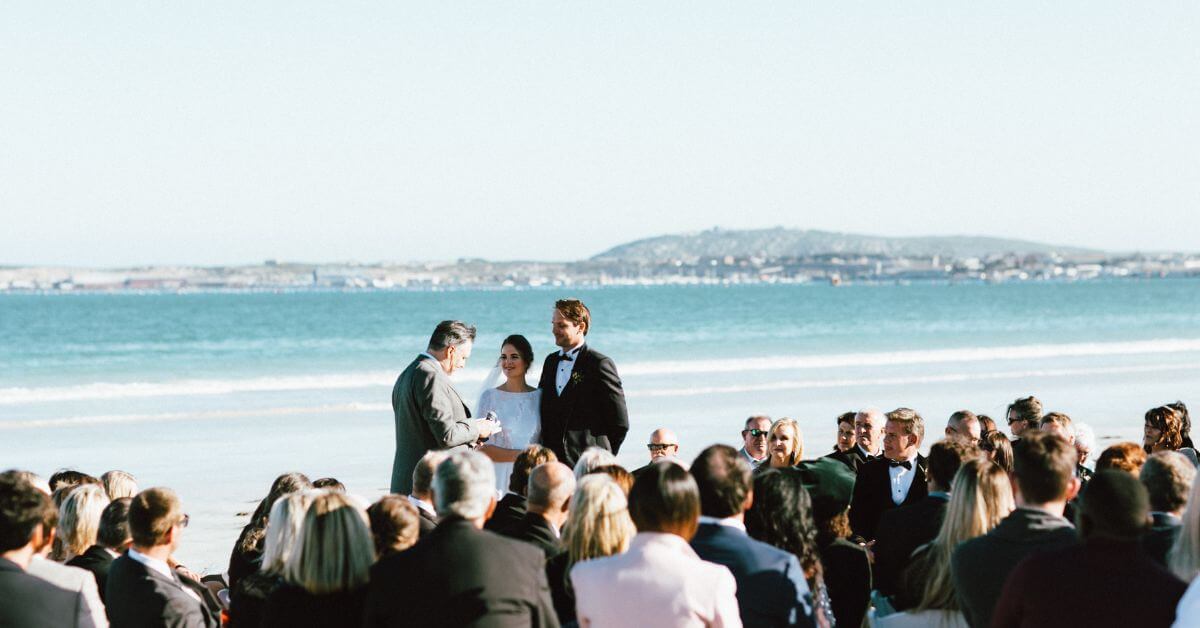 Couple getting married on the beach with the ocean in the background